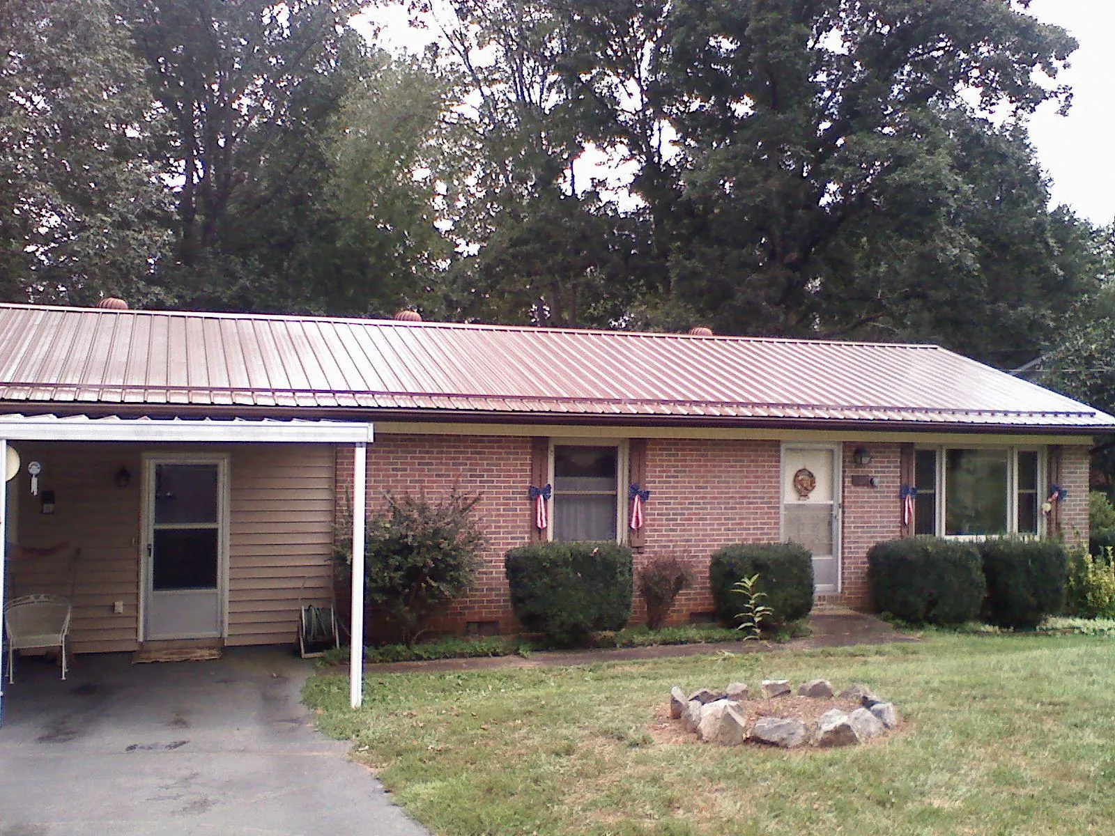 Bronze metal roof and carport on a brick ranch home — Roof Repair work by our crew in Dallas City